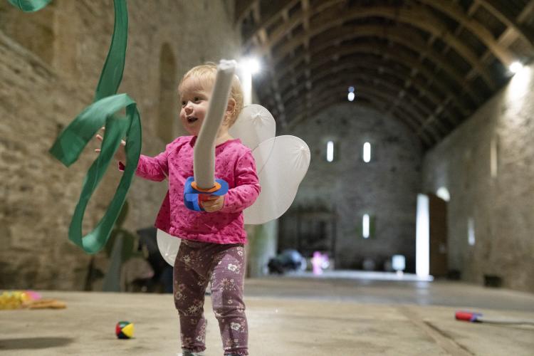 child playing in the medieval barn at Buckland Abbey