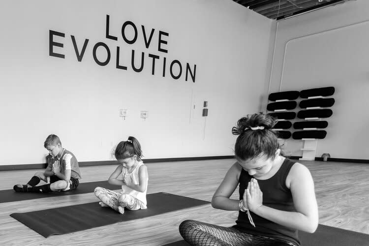 Family with hands at heart center at Love Evolution Studio