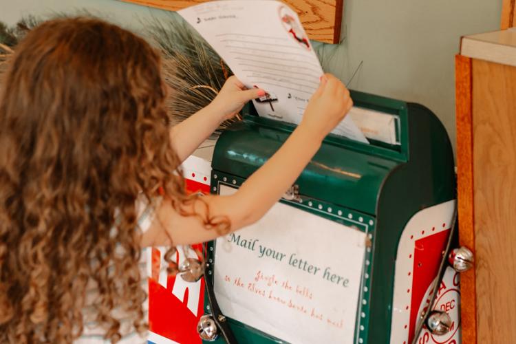Girl sending letter to Santa via Mail box IN Santa Claus Indiana