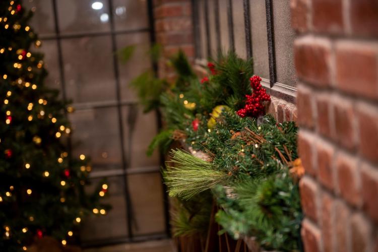 christmas tree and wreath along a brick wall