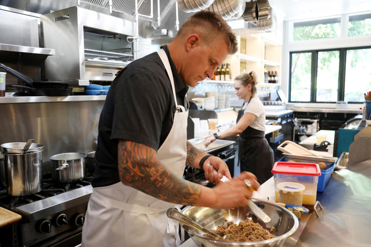 Chef Scott Crawford works to prepare a dish in the kitchen on one of his restaurants