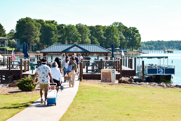 A group walking toward a dock toward The Catawba Riverkeeper Floating Classroom on Lake Norman.