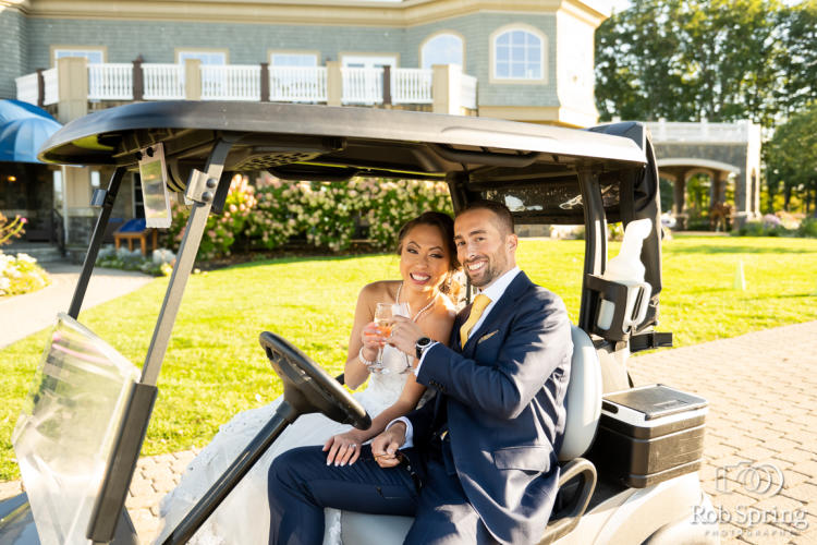 Bride and groom toasting in a golf cart