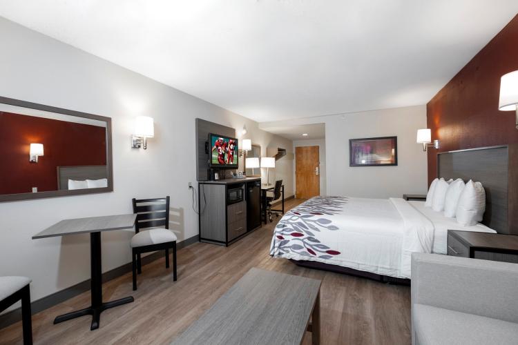 Interior of King size room shown at long angle with large bed, TV table and chairs
