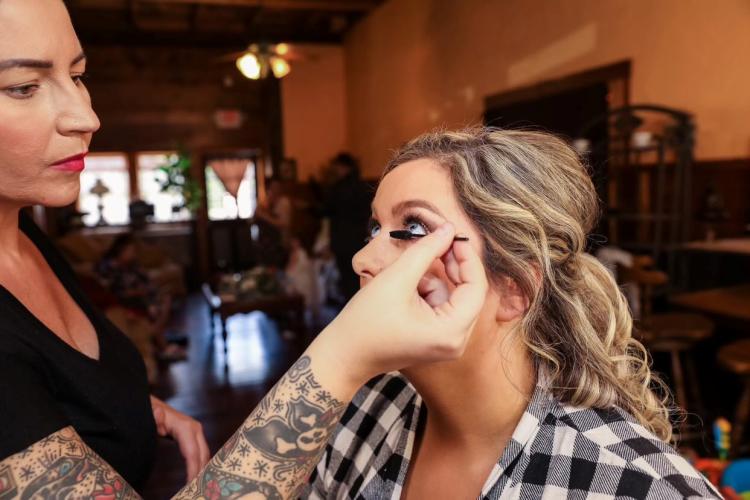 Fawn applying mascara to a bride