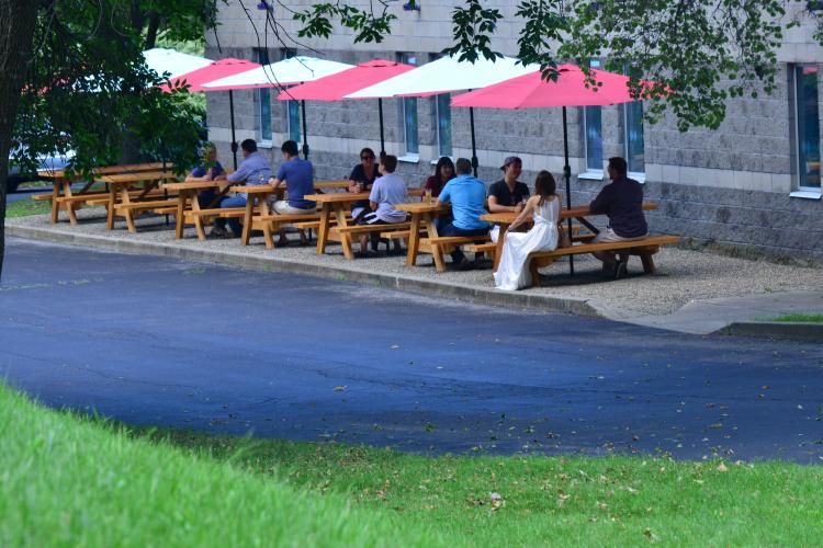 Far away shot of people sitting on patio furniture at Racing City Brewery