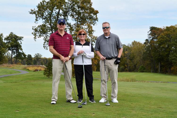 Thomas Olsen and two others standing together holding golf clubs in front of them for pose