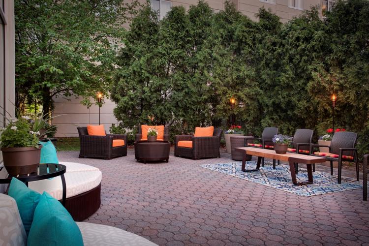 Dusk shot of orange and teal seating at Hilton Garden Inn Saratoga Springs patio