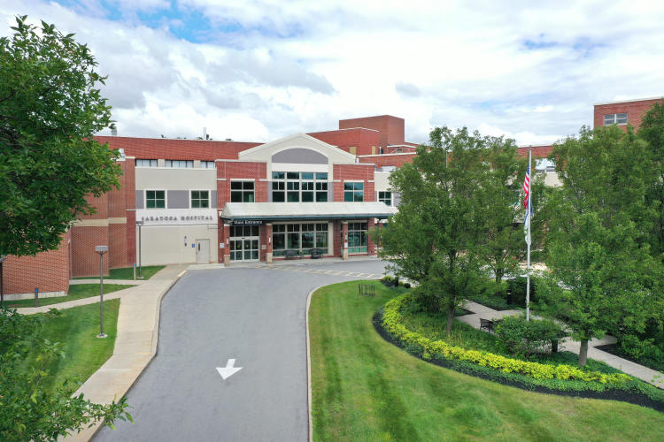 Exterior shot of Saratoga Hospital taken from the air and looking down over green lawns and driveway