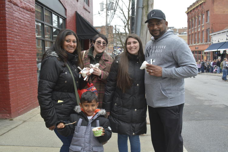 Four adults and one child posing and holding chowders