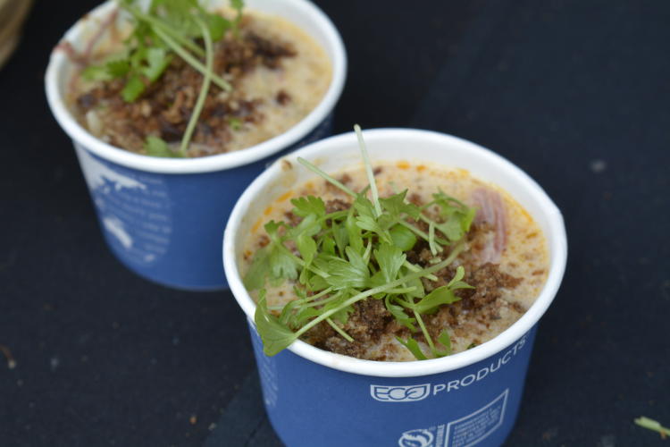 Two blue paper bowls filled with chowder and topped with cilantro