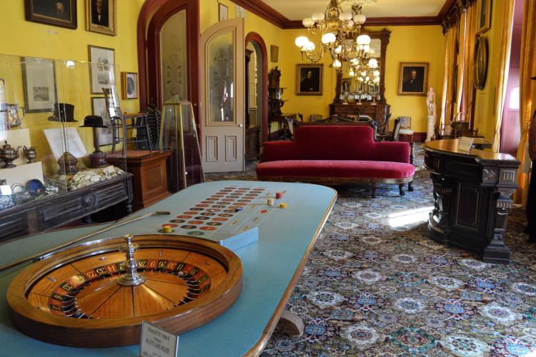 Roulette wheel in Casino High Stakes Gambling Room with lavish furnishings in background