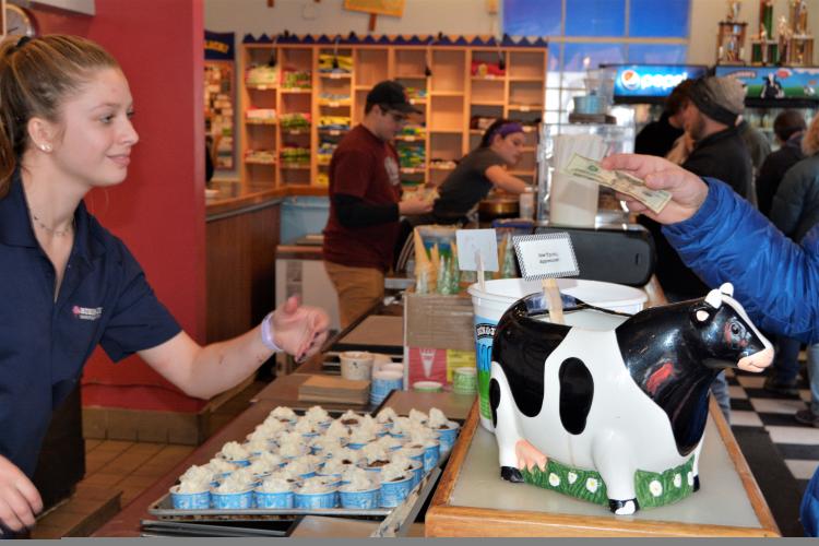 Cashier at Ben and Jerrys taking money at counter