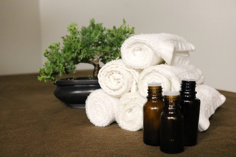Swedish Hill Farm and Spa pile of rolled towels and 3 bottles of oils displayed
