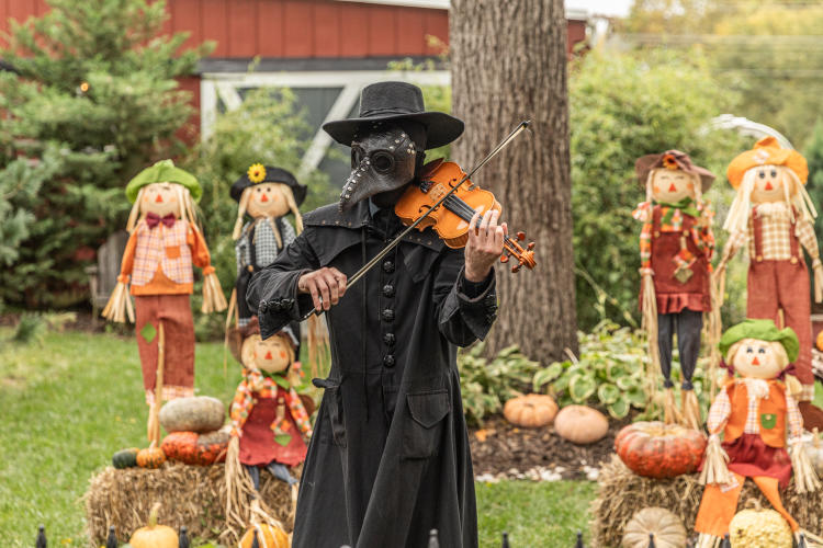 Legends & Lanterns man in a plague mask playing a violin