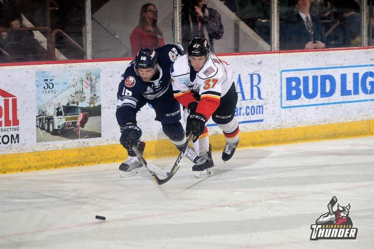 Adirondack thunder player and opponent going after the puck
