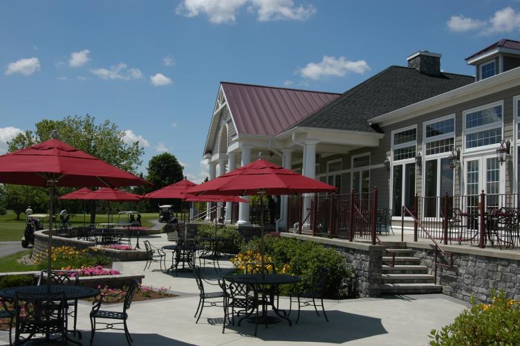 Outdoor seating with red umbrellas at Van Patten Golf Club