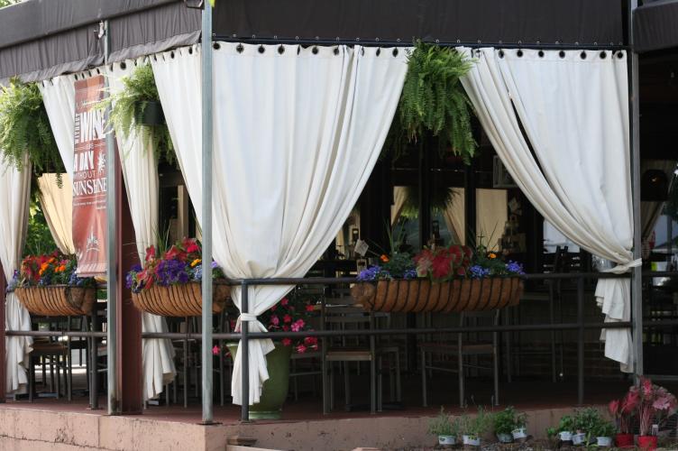 Shot of Pasta Pane Rustic Italian Bistro's patio with white drapes and colorful plants
