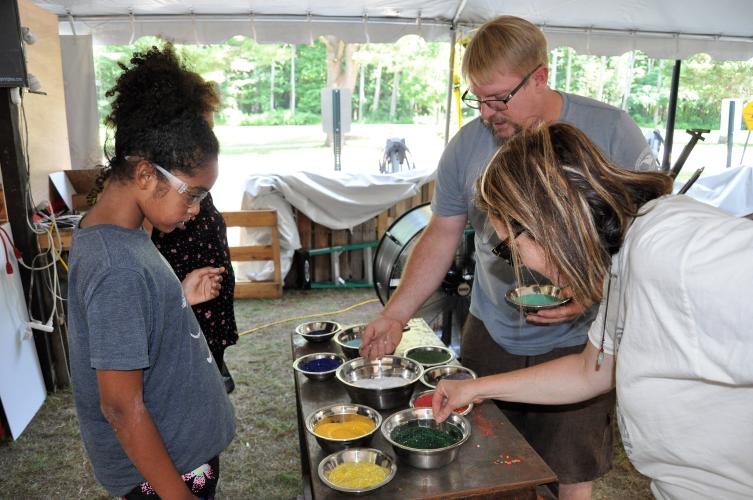 Gina and Oia selecting their colors from silver bowls with Greg's assistance