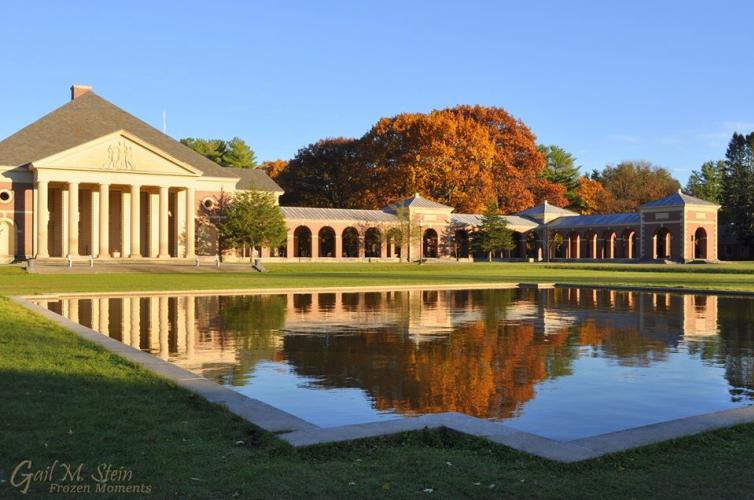 State Park bldg with golden foliage behind it, all shining in the reflecting pool