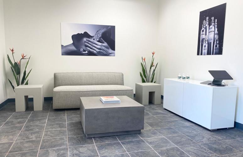 Empty waiting lounge with modular furniture and white walls, gray floor