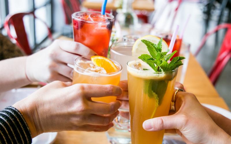 Four people cheersing cocktails at Cardinal Spirits