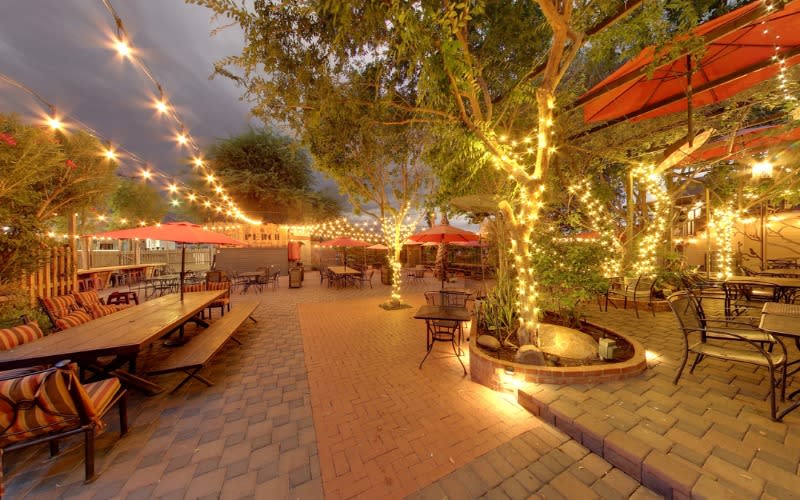 Lights on trees and hanging above patio at the Perch Brewery in the evening.