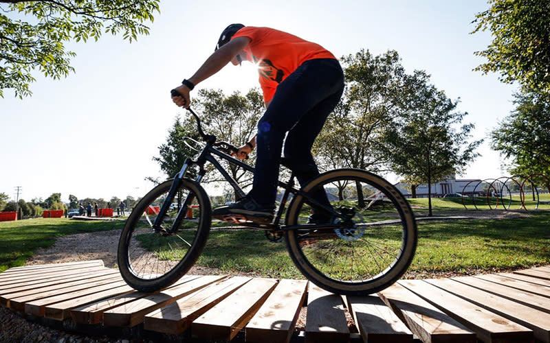 Dayton Bike Yard, showing a man riding a mountain bike on a wood plank path