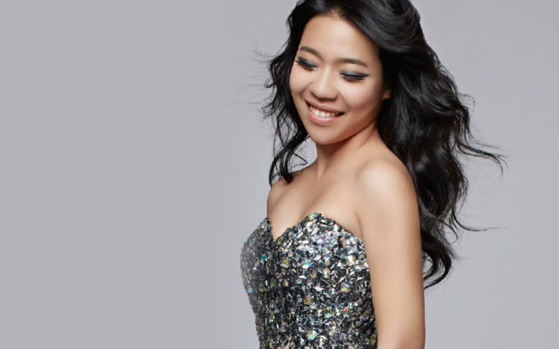 Joyce Yang smiles while posing for a photo in a sparkly dress