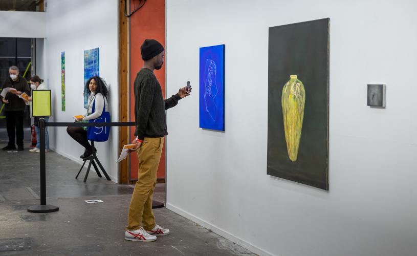 A man photographing one of the works at the Open Studios exhibition in the Spike Island art gallery on Bristol's Harbourside