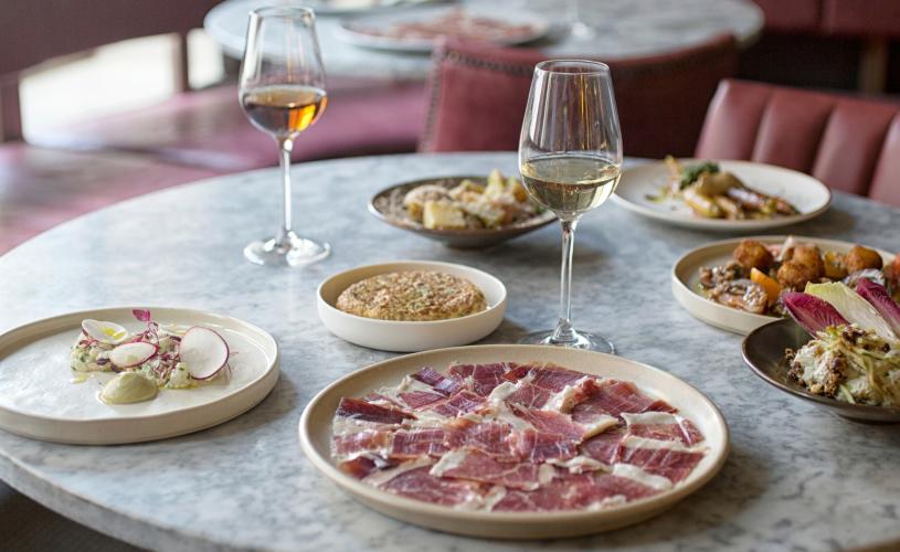 Two glasses of wine and seven small plates on a table at Bar 44 in Clifton, West Bristol - credit Bar 44