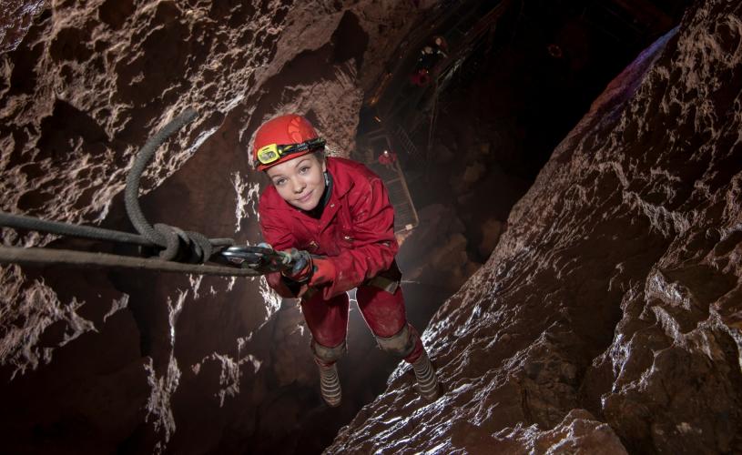 A girl abseiling on the Wild Wookey caving experience in Wookey Hole in Wells, near Bristol - credit Wookey Hole