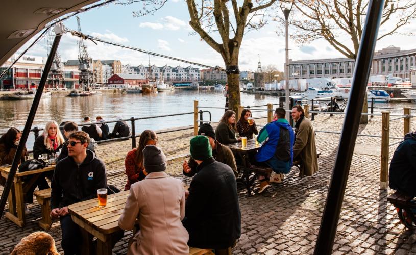 People sitting on the outdoor tables at the Arnolfini Harbourside Bar on Bristol's Harbourside - credit Arnolfini Bristol