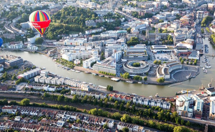 An aerial view of hot air balloons flying over Bristol Harbourside