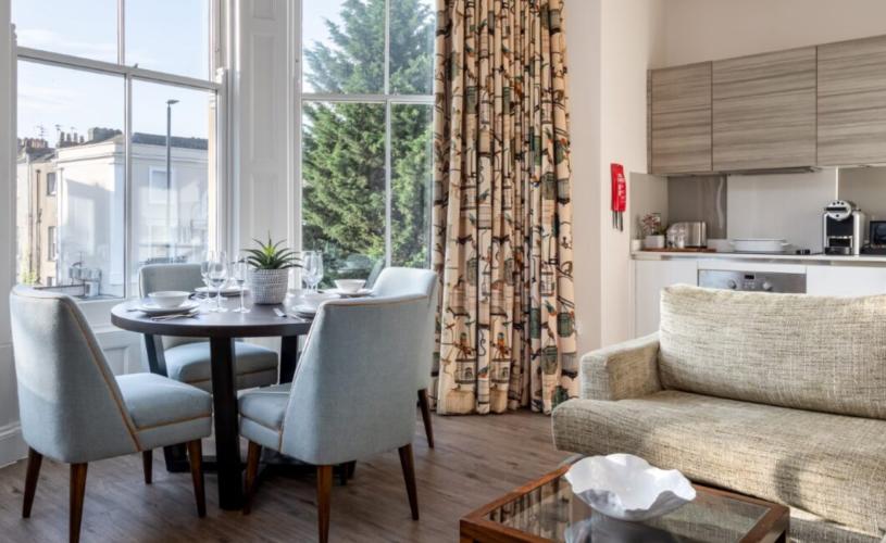Dining room table and kitchen in Beech House - Credit Urban Apartments