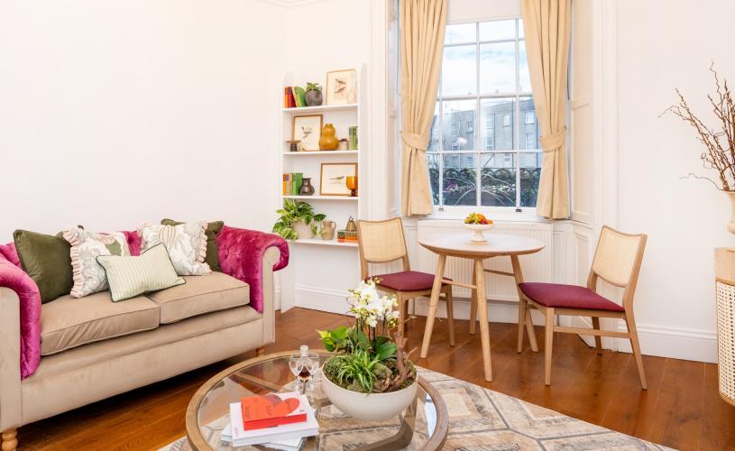 A lounge with sofa and small table and chairs - Credit Berkeley Suites