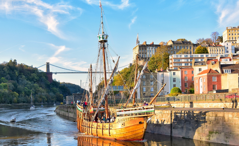 A view of The Matthew replica ship passing through Bristol's Cumberland Basin with the Clifton Suspension Bridge in the background - credit Nick Greville