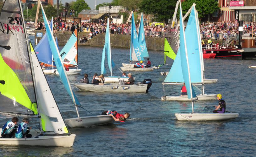 A group of boats with pale blue sails in the water - Credit All Aboard Watersports