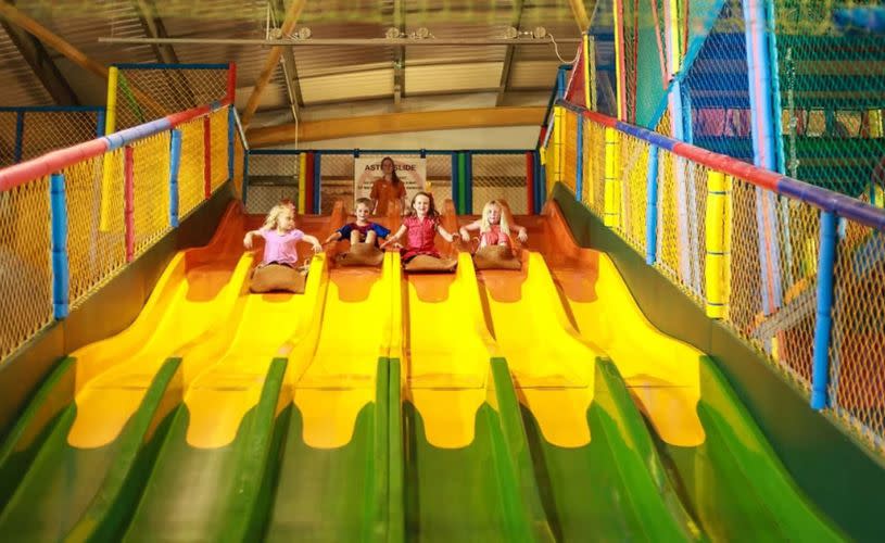 Children on bright yellow slide at Puxton Park near Bristol - credit Puxton Park