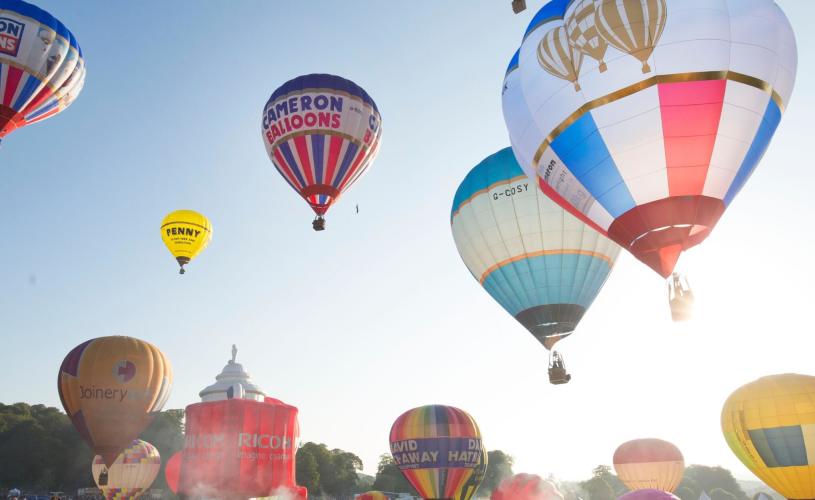 A group of balloons lifting off in a mass ascent at Bristol International Balloon Fiesta - credit Paul Box