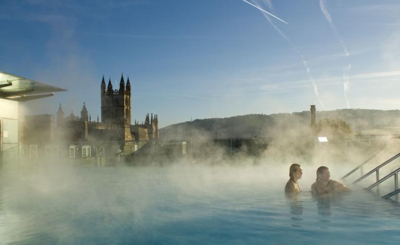 Couple on stairs at the rooftop pool at the Thermae Bath Spa at night