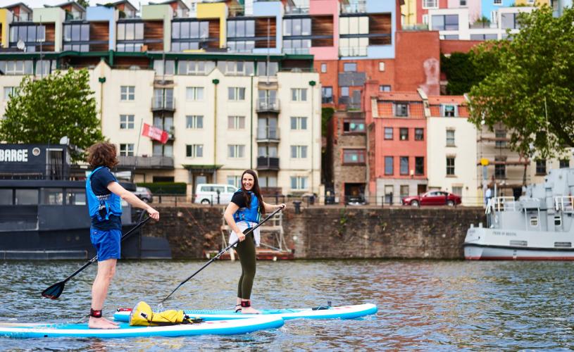 Person stand up paddleboarding in Bristol harbour - credit SUP Bristol