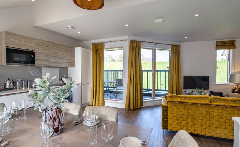 Dining room table and kitchen in Beech House - Credit Urban Apartments