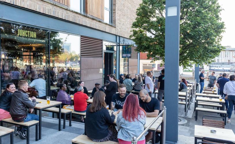 People sitting at tables at the Junction bar - credit Bristol Beer Factory