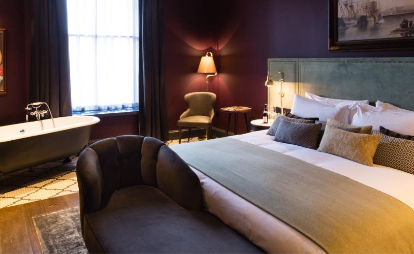 Luxury hotel room with blue walls and bathtub in room