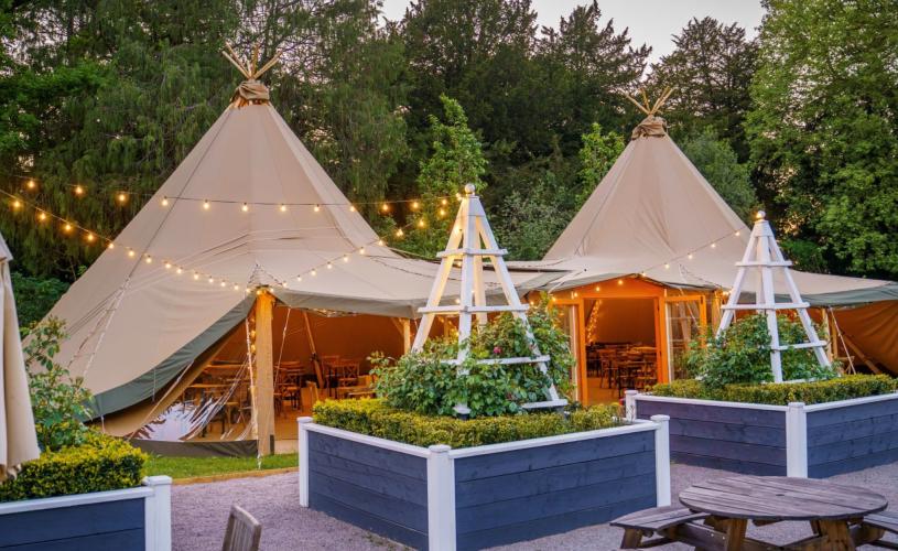 De vere Tortworth Court near Bristol exterior with outdoor seating and tipis in garden - credit De vere Tortworth Court
