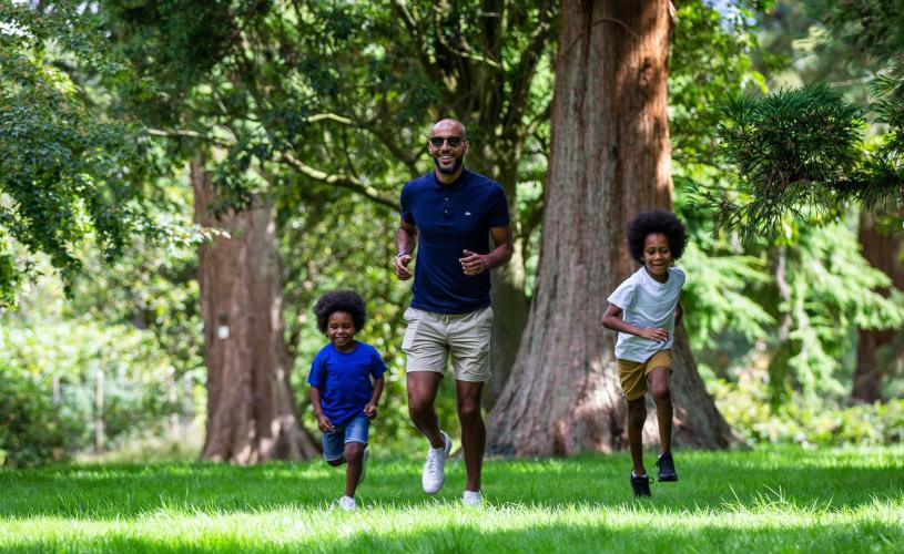 Children and father running through trees at Westonbirt Arboretum - credit Johnny Hathaway