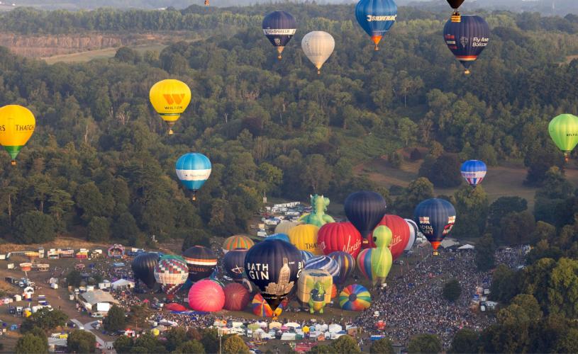 Balloons lifting off in a mass ascent at Bristol International Balloon Fiesta 2025