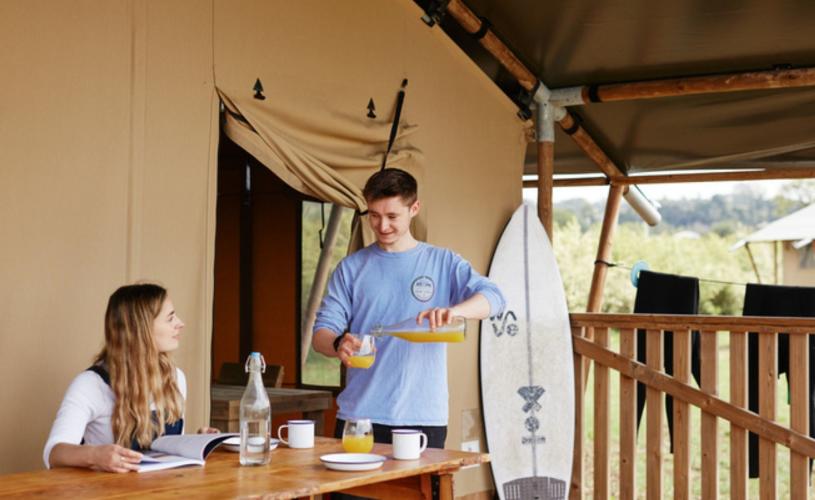 People eating breakfast outside tent - credit The Wave
