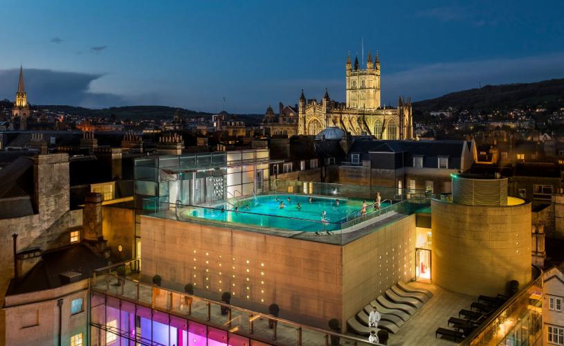 An aerial view of the rooftop pool at the Thermae Bath Spa at night